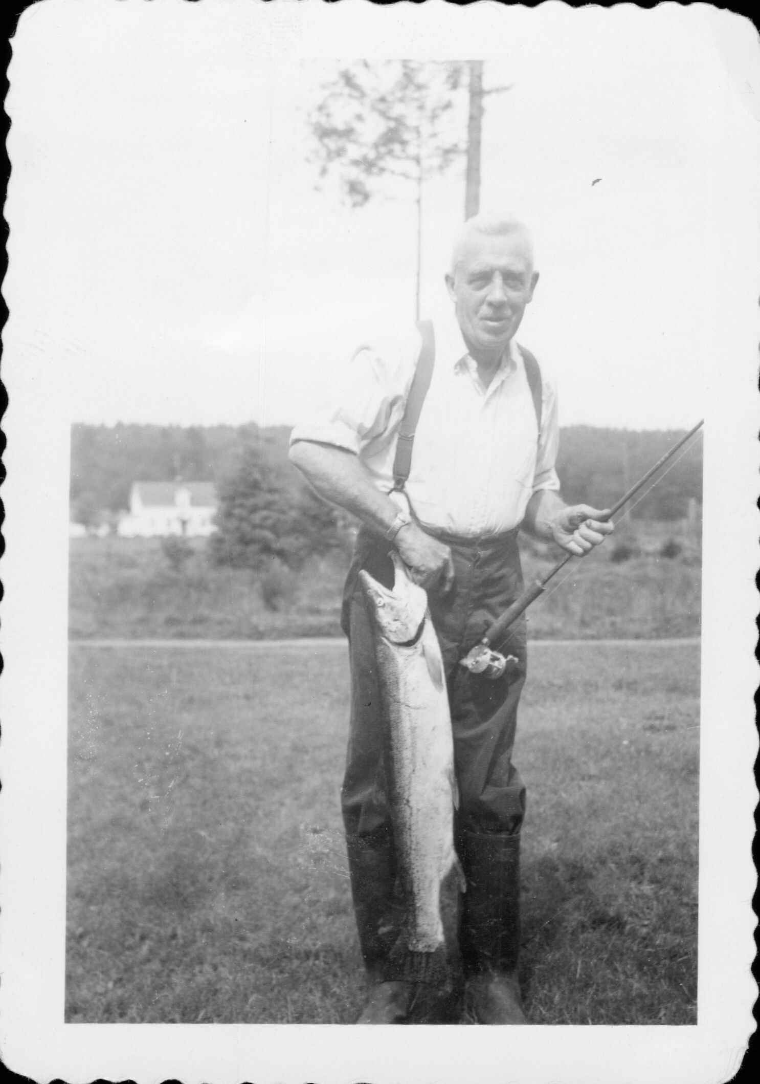 Dr. Manch N. Garhart holding fish caught in Lake Dell